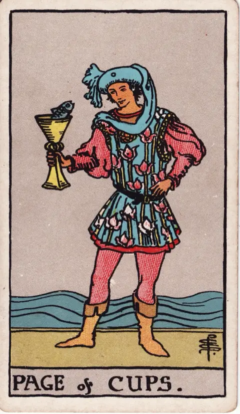 Page of Cups, from the 1909 Rider-Waite-Smith deck: a young man in a flowered tunic stands by the sea holding a cup from which a small fish looks out at him.