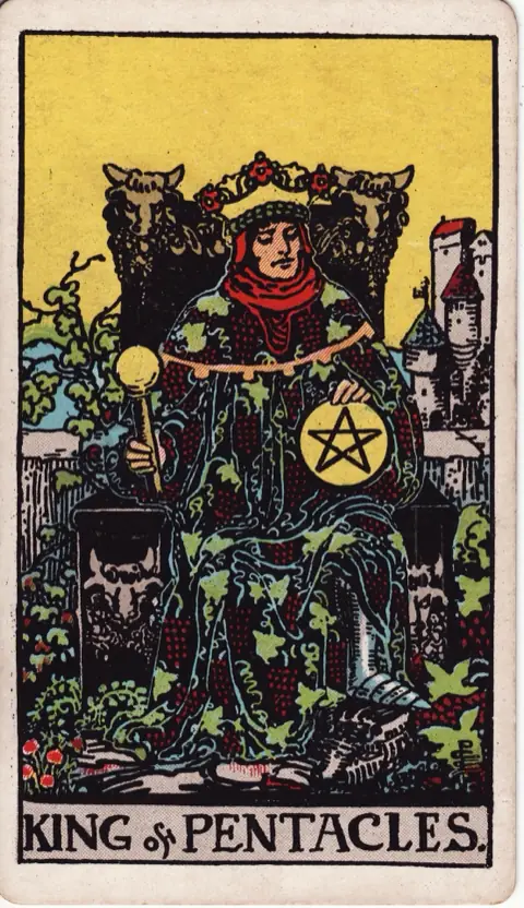 King of Pentacles, from the 1909 Rider-Waite-Smith deck: a king in a robe embroidered with grapes sits on a throne carved with bulls’ heads, holding a pentacle and a sceptre, a castle behind him.