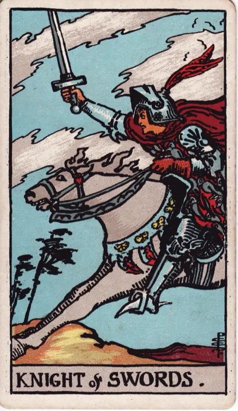 Knight of Swords, from the 1909 Rider-Waite-Smith deck: a knight in armour charges at full gallop on a white horse, sword raised, the clouds and trees torn by the wind.